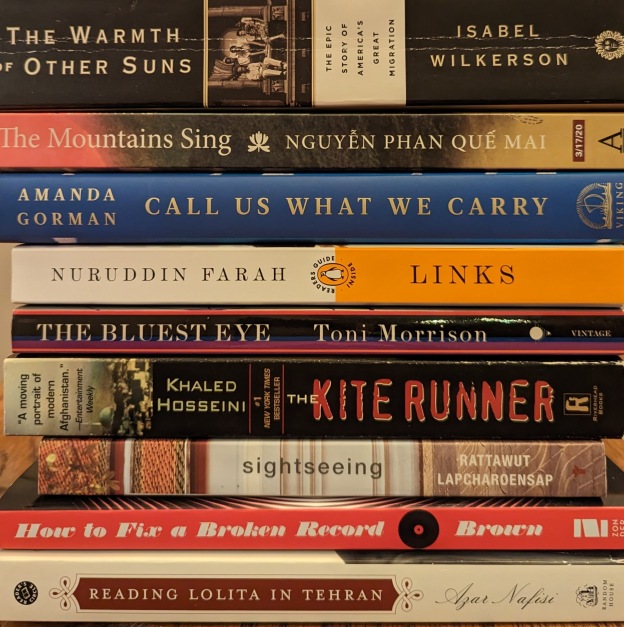 A stack of books, some read, some to-be-read. Many are memoir, but there is realistic fiction and history and poetry. Titles include The Warmth of Other Suns by Isabel Wilkerson, The Mountains Sing by Nguyen Phan Que Mai, Call Us What We Carry by Amanda Gorman, Links by Nuruddin Farah, The Bluest Eye by Toni Morrison, The Kite Runner by Khaled Hosseini, Sightseeing by Rattawut Lapcharoensap, How to Fix a Broken Record by Amena Brown, and Reading Lolita in Tehran by Azar Nafisi
